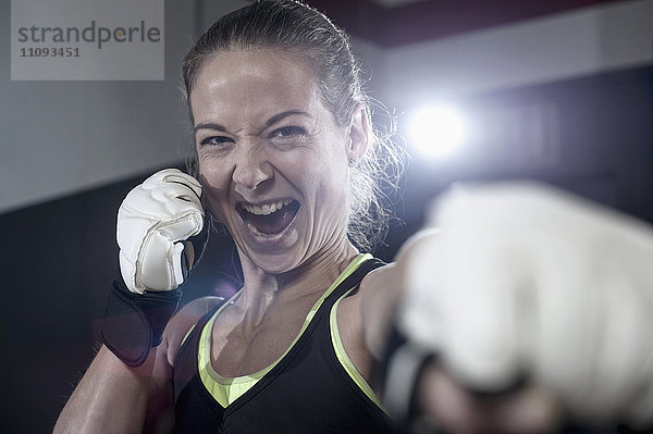 Porträt einer Sportlerin in Boxerpose in der Turnhalle