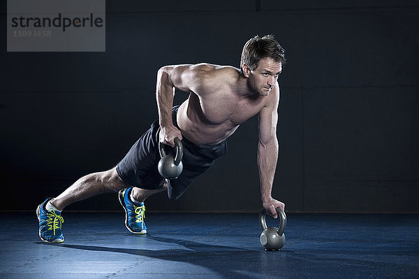 Sportler beim Training im Fitnessstudio mit Kettlebell