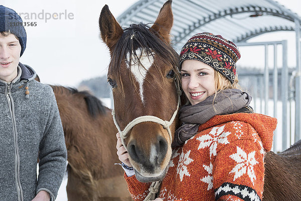 Junges Paar mit Pferd stehend und lächelnd  Bayern  Deutschland