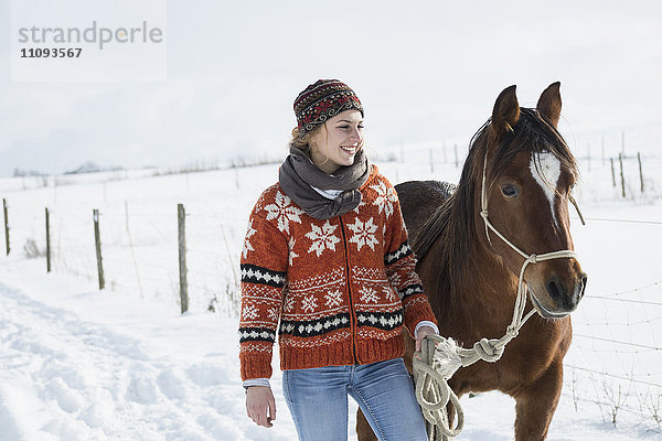 Junge Frau stehend mit Pferd auf dem Bauernhof  Bayern  Deutschland