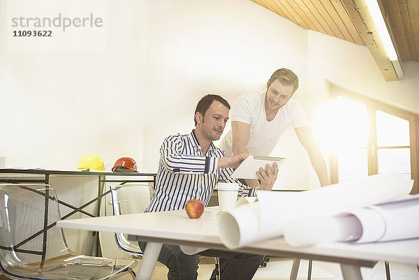 Architekten diskutieren über ein Projekt auf einem digitalen Tablet in einem Büro  Bayern  Deutschland