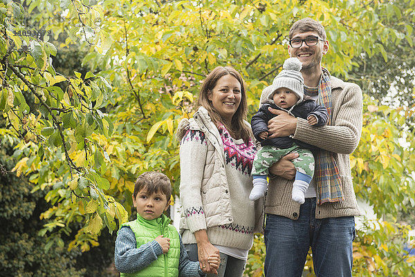 Porträt einer lächelnden Kleinfamilie auf einem Biohof