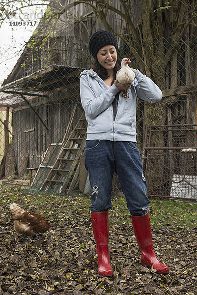 Bäuerin mit weißem Huhn auf dem Bauernhof