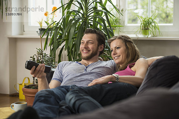 Ehepaar beim Fernsehen im Wohnzimmer  München  Bayern  Deutschland