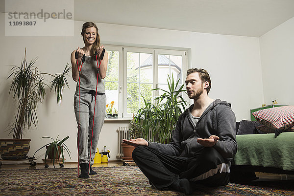 Ehepaar beim Sport im Wohnzimmer  München  Bayern  Deutschland