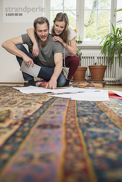 Ehepaar betrachtet Karte im Wohnzimmer  München  Bayern  Deutschland