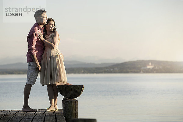 Älteres Paar steht auf einem Steg und blickt über einen See  Bayern  Deutschland