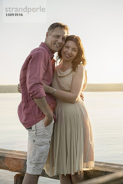 Porträt eines lächelnden reifen Paares auf einem Steg am See  Bayern  Deutschland