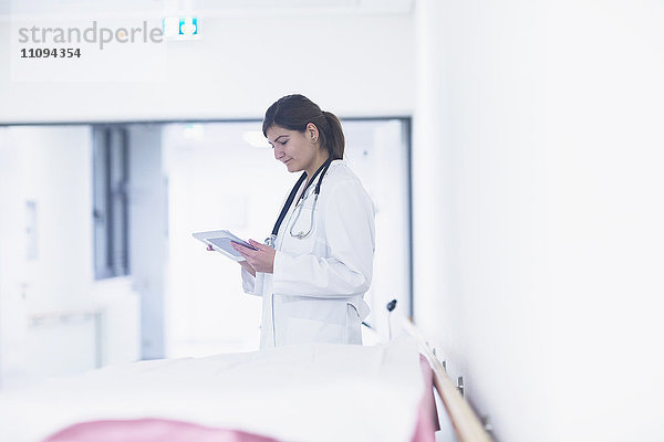 Junge Ärztin bei der Benutzung eines digitalen Tablets im Krankenhaus