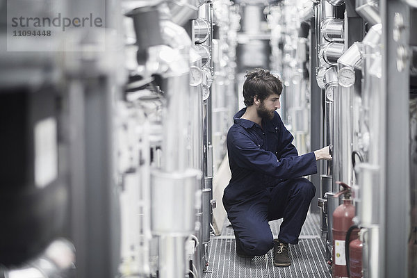 Junger männlicher Ingenieur bei der Arbeit in einer Industrieanlage