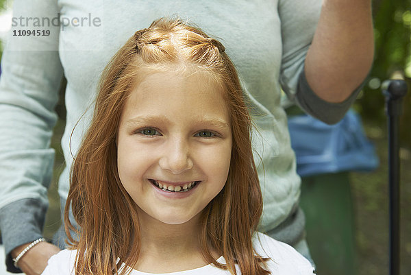 Porträt eines lächelnden Mädchens mit seiner Mutter beim Picknick  München  Bayern  Deutschland