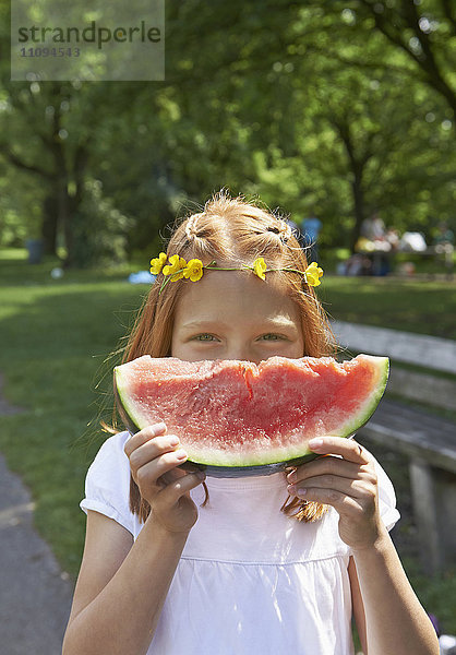 Porträt eines Mädchens  das bei einem Picknick ein Stück Wassermelone genießt  München  Bayern  Deutschland
