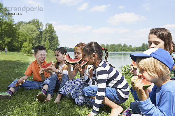 Kinder genießen Scheiben von Wassermelonen beim Picknick  München  Bayern  Deutschland