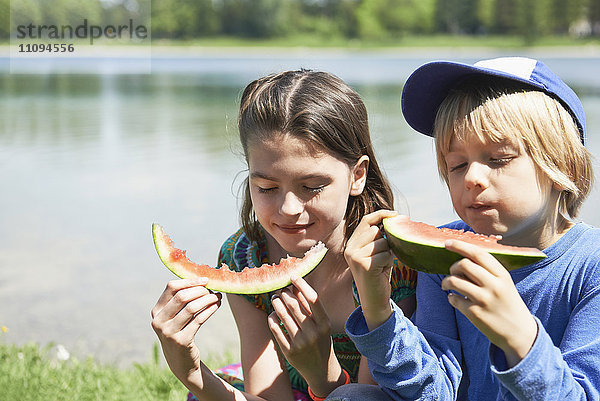 Kinder genießen Scheiben von Wassermelonen beim Picknick  München  Bayern  Deutschland