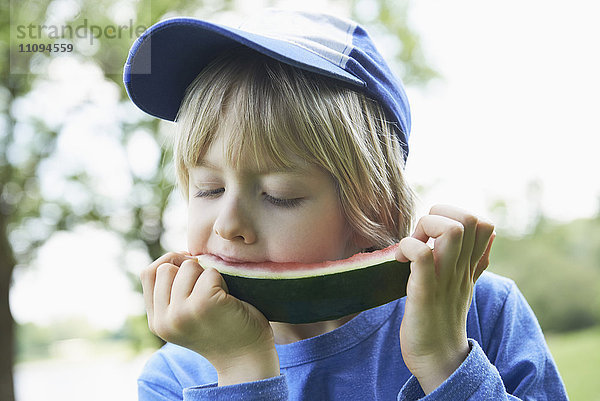 Junge genießt ein Stück Wassermelone beim Picknick  München  Bayern  Deutschland