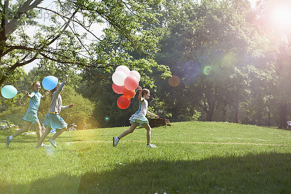 Mädchen laufen im Park mit Luftballons  München  Bayern  Deutschland
