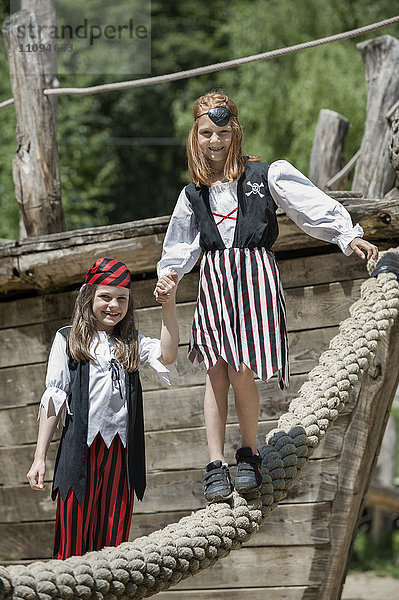 Zwei als Piraten verkleidete Mädchen spielen auf einem Abenteuerspielplatz  Bayern  Deutschland