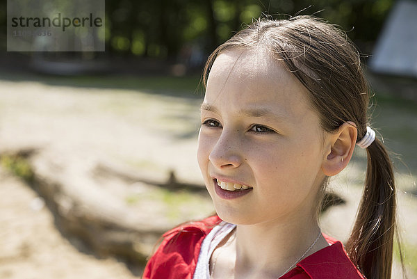 Nahaufnahme eines lächelnden Mädchens auf einem Spielplatz  Bayern  Deutschland