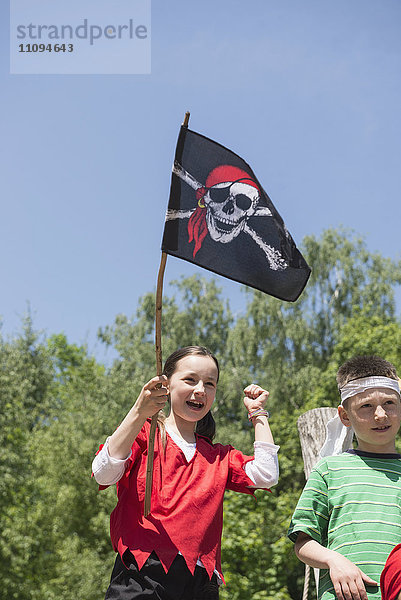 Mädchen hält Piratenflagge mit ihrer Freundin auf einem Abenteuerspielplatz  Bayern  Deutschland