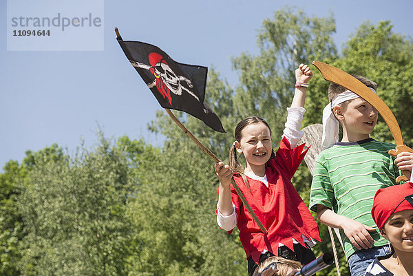 Mädchen mit Piratenflagge und ihren Freunden auf einem Abenteuerspielplatz  Bayern  Deutschland