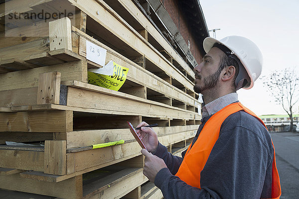 Junger männlicher Ingenieur bei der Arbeit auf einer Baustelle