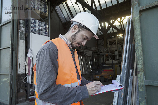 Junger männlicher Ingenieur bei der Arbeit auf einer Baustelle