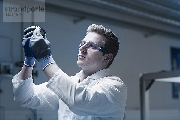 Junger männlicher Wissenschaftler in einem optischen Labor