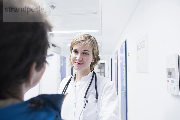 Junger Arzt im Gespräch mit einem Patienten in einem Krankenhaus