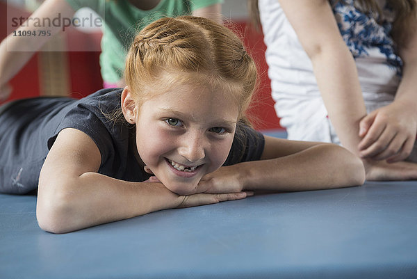 Mädchen liegt auf einer Turnmatte in der großen Turnhalle einer Schule  Bayern  München  Deutschland