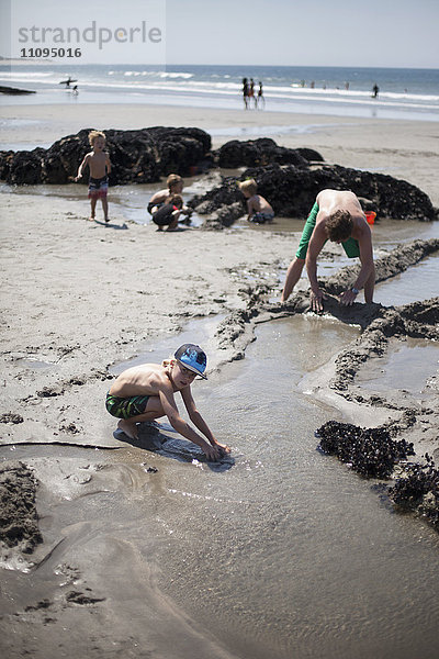 Vater baut mit seinen Kindern eine Sandburg am Strand  Viana do Castelo  Region Norte  Portugal