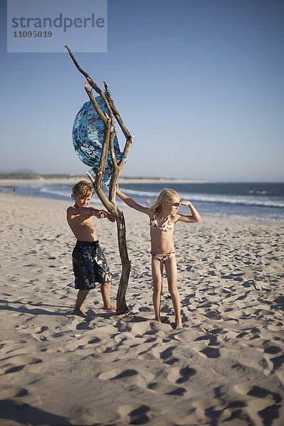 Zwei Kinder spielen mit Holz am Strand  Viana do Castelo  Region Norte  Portugal