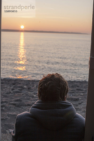 Rückansicht eines reifen Mannes bei Sonnenuntergang am Strand  Renesse  Schouwen-Duiveland  Zeeland  Niederlande