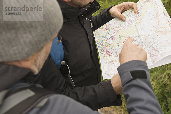 Zwei erwachsene Wanderer  die auf der Karte den richtigen Weg suchen  Österreichische Alpen  Kärnten  Österreich
