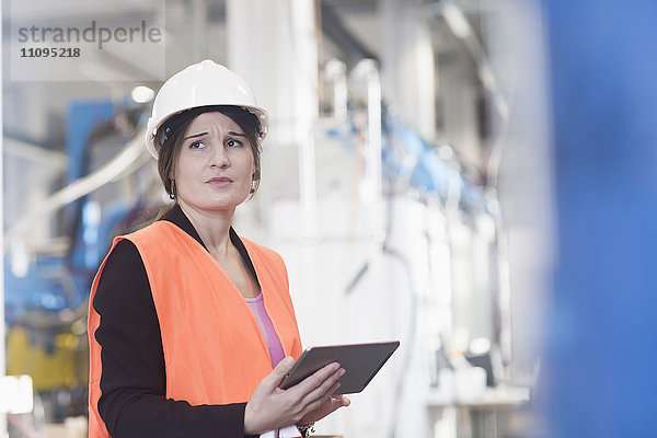 Ingenieurin bei der Arbeit mit einem digitalen Tablet in einer Industrieanlage  Freiburg im Breisgau  Baden-Württemberg  Deutschland