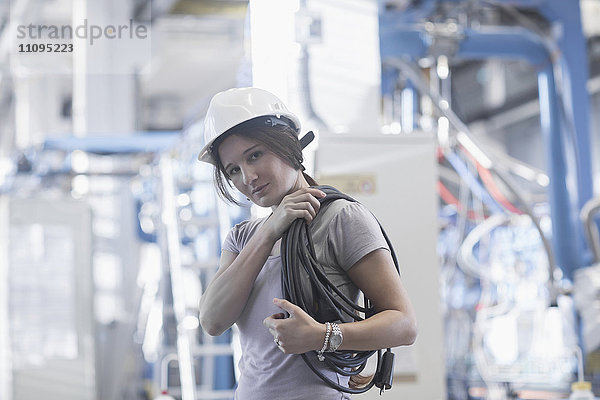 Porträt einer Technikerin  die eine Seilrolle auf der Schulter trägt  in einer Industrieanlage  Freiburg im Breisgau  Baden-Württemberg  Deutschland