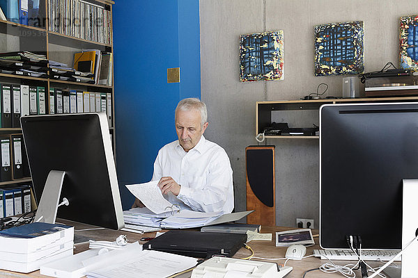 Älterer Geschäftsmann bei der Arbeit im Büro  Freiburg im Breisgau  Baden-Württemberg  Deutschland