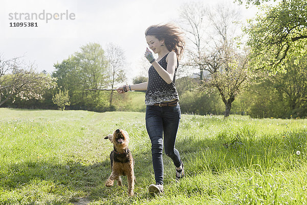 Teenagerin läuft mit ihrem Hund im Park  Freiburg im Breisgau  Baden-Württemberg  Deutschland