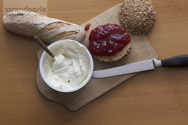 Frisches Baguette  Käse  Marmelade  Brötchen auf Schneidebrett