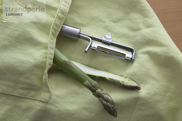 Halber Spargel mit Sparschäler in der Schürzentasche