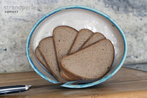 Brotscheiben und ein Messer in einer Schüssel anbraten