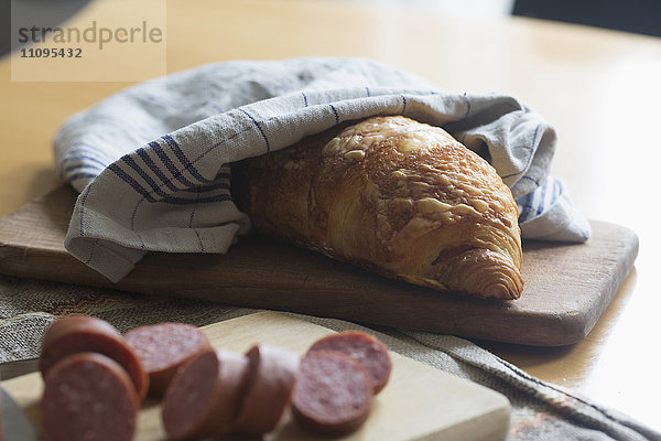 Croissant und Wurstscheiben auf Schneidebrett  Freiburg im Breisgau  Baden-Württemberg  Deutschland