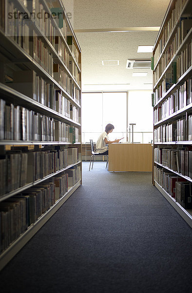 Studentin beim Lesen in der Bibliothek