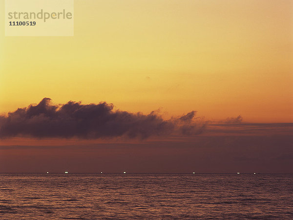 Sonnenuntergang über dem Meer  Fischerei Lichter in der Ferne