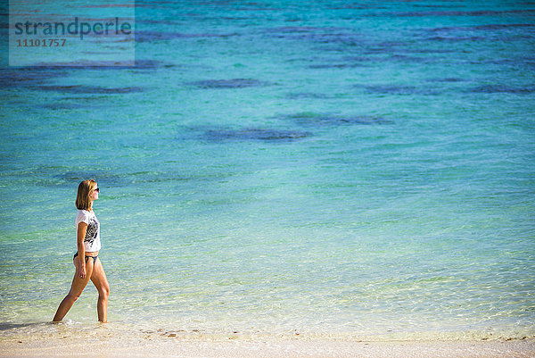 Frau  die an einem tropischen Strand spazieren geht  Insel Rarotonga  Cookinseln  Südpazifik  Pazifik