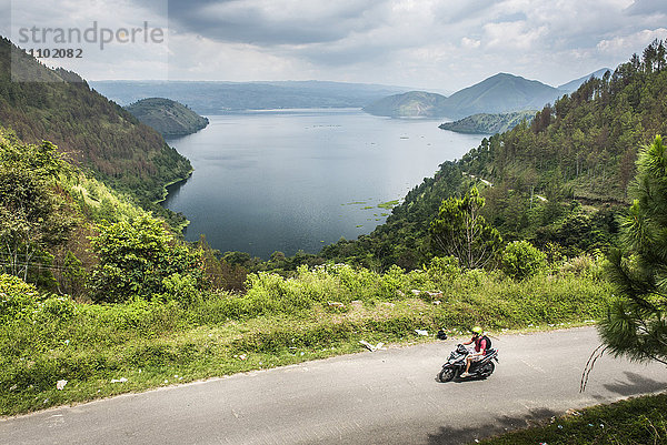 Tourist erkundet den Toba-See (Danau Toba) mit dem Motorrad  Nordsumatra  Indonesien  Südostasien  Asien