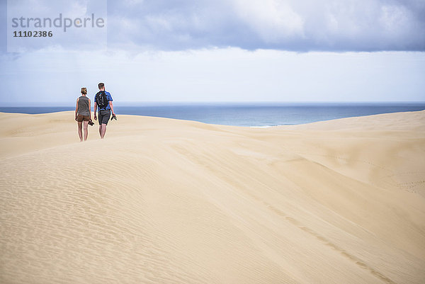 Zwei Touristen in den Te Paki Sanddünen am 90 Mile Beach  Northland  Neuseeland  Pazifik