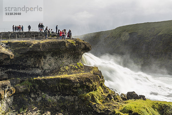 Touristen besuchen den Gullfoss (Goldener Wasserfall)  einen Wasserfall in der Schlucht des Flusses Hvita im Südwesten Islands  Polarregionen