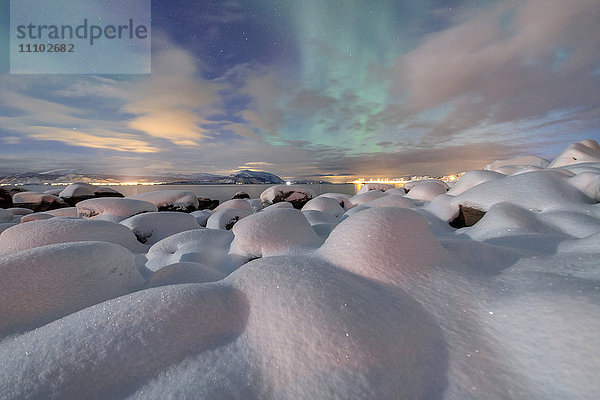 Das rosafarbene Licht und die Aurora borealis (Nordlichter) erhellen die Schneelandschaft in einer sternenklaren Nacht Stronstad  Lofoten  Arktis  Norwegen Skandinavien  Europa