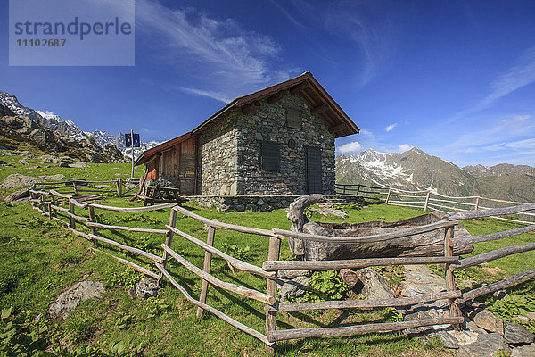 Grüne Wiesen und Berghütte an einem sonnigen Sommertag  Orobie Alpen  Arigna Tal  Sondrio  Valtellina  Lombardei  Italien  Europa