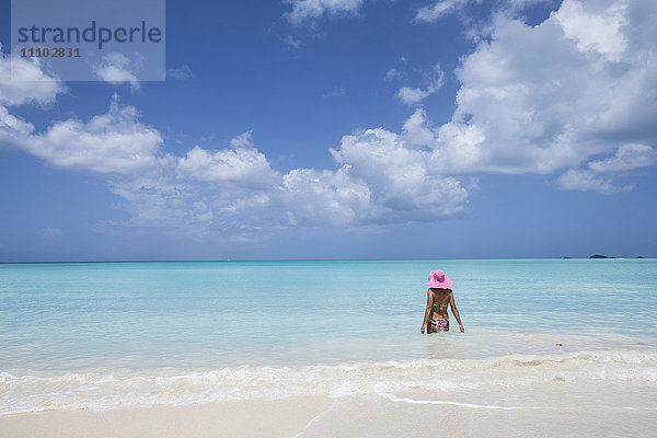 Eine Badende mit einem rosa Hut im türkisfarbenen Wasser der Karibik  The Nest  Antigua  Antigua und Barbuda  Leeward-Inseln  Westindien  Karibik  Mittelamerika